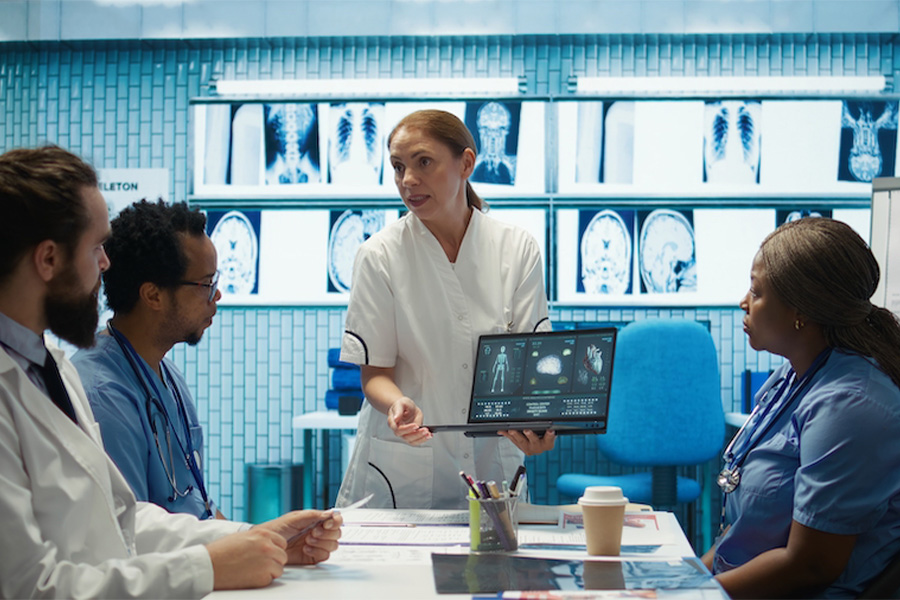 Team of doctors discuss results of X-Ray or MRI scan of patient's brain in medicine office of clinic